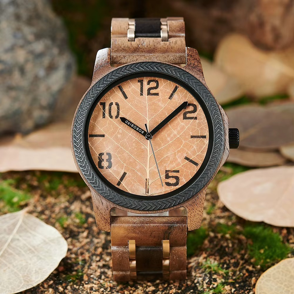 Montre Ambre en bois de noyer avec cadran feuille beige et lunette noire, chiffres arabes visibles, vue rapprochée sur le cadran