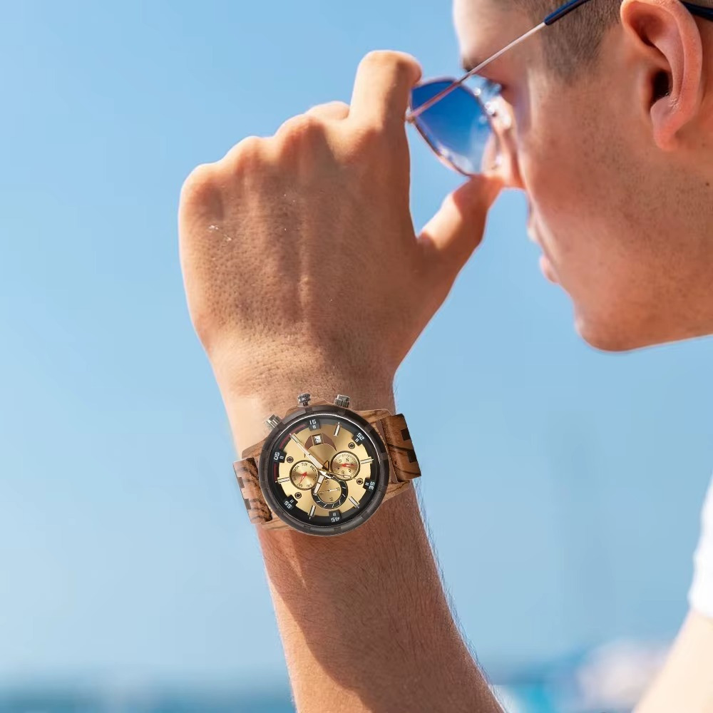 Montre Atlas en bois bicolore avec chronographe et calendrier complet portée au poignet d'une personne de profil