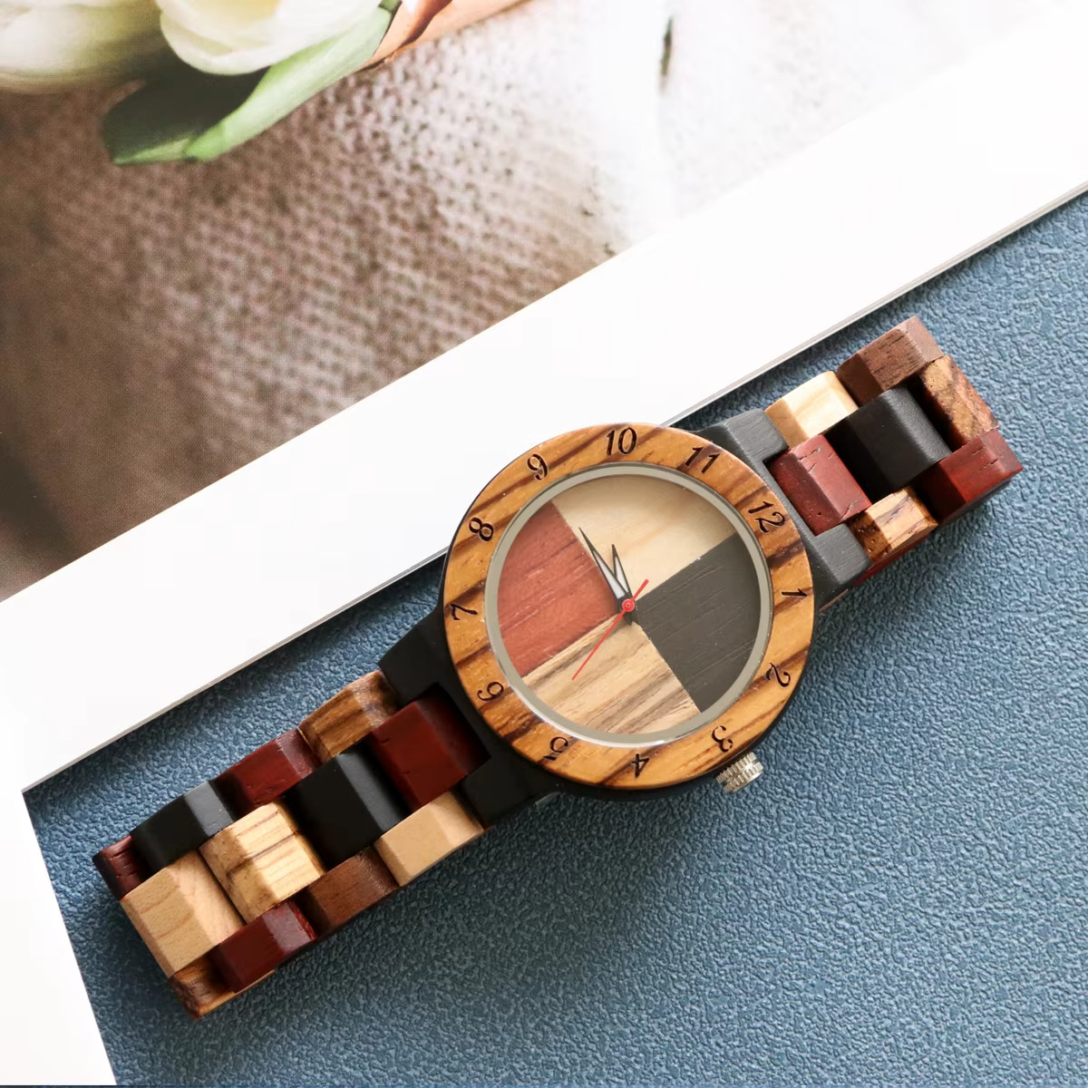 Montre Bahia pour femme en bois avec cadran marqueté et bracelet multi-essences vue en plongée sur fond bleu