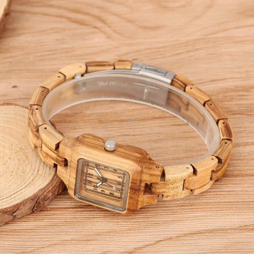 Montre en bois femme Lucerne avec cadran carré 26 mm et bracelet en bois fin posé sur surface en bois