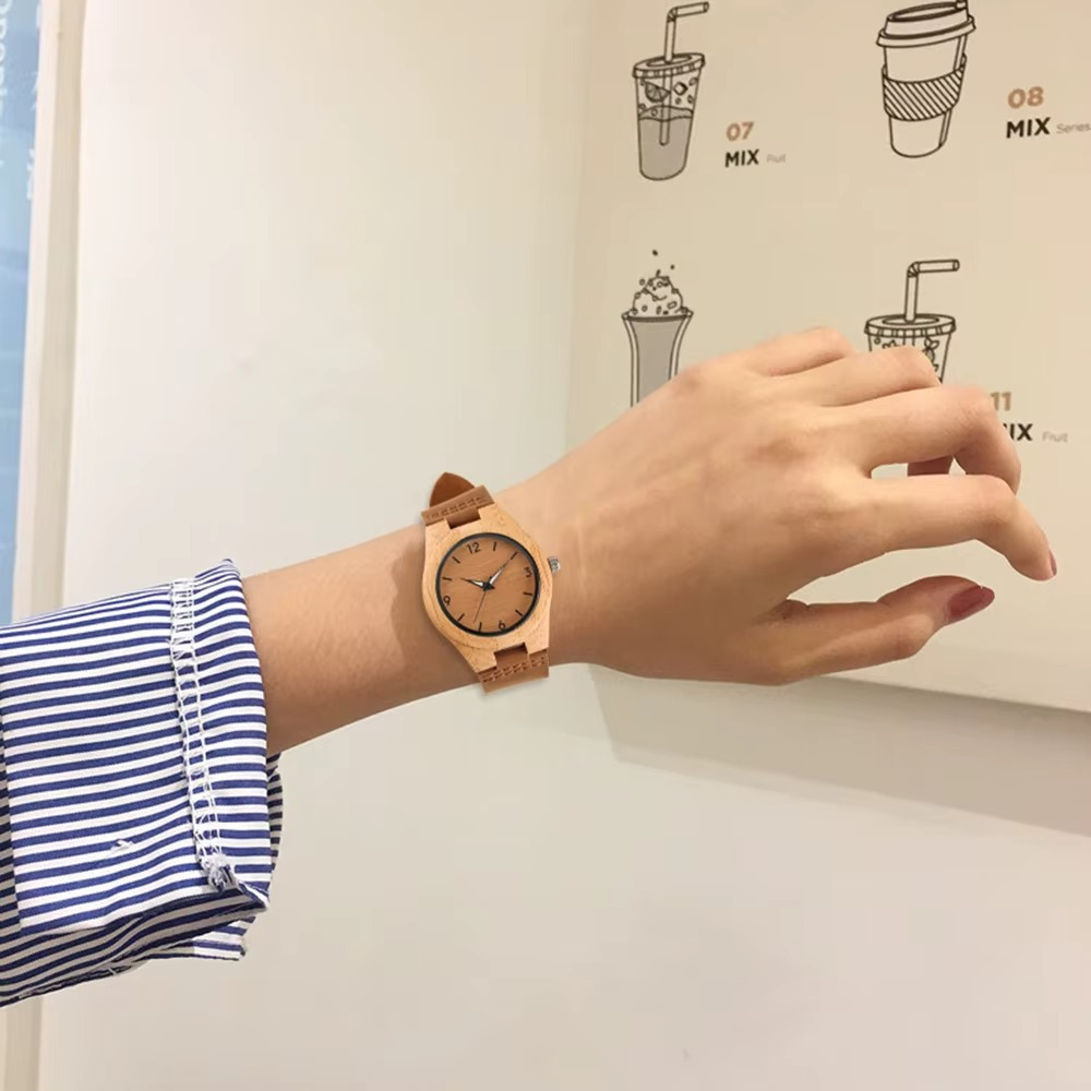Montre en bois femme modèle Moka avec cadran couleur café et bracelet en cuir marron portée au poignet