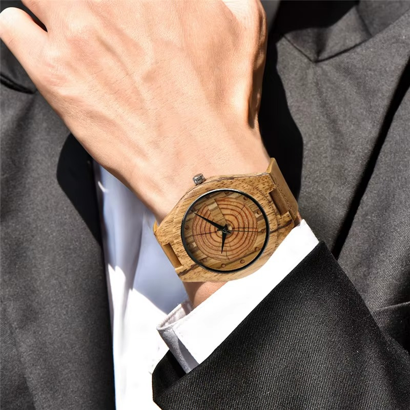 Montre en bois faite main homme avec cadran en cernes d'arbre et bracelet en cuir camel portée au poignet