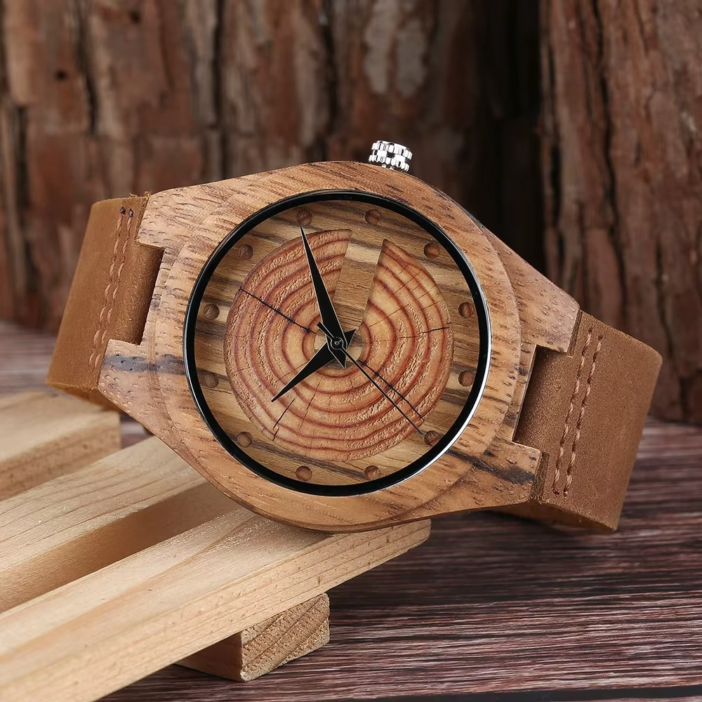 Montre en bois faite main pour homme avec cadran en cernes d'arbre et bracelet en cuir camel vue rapprochée