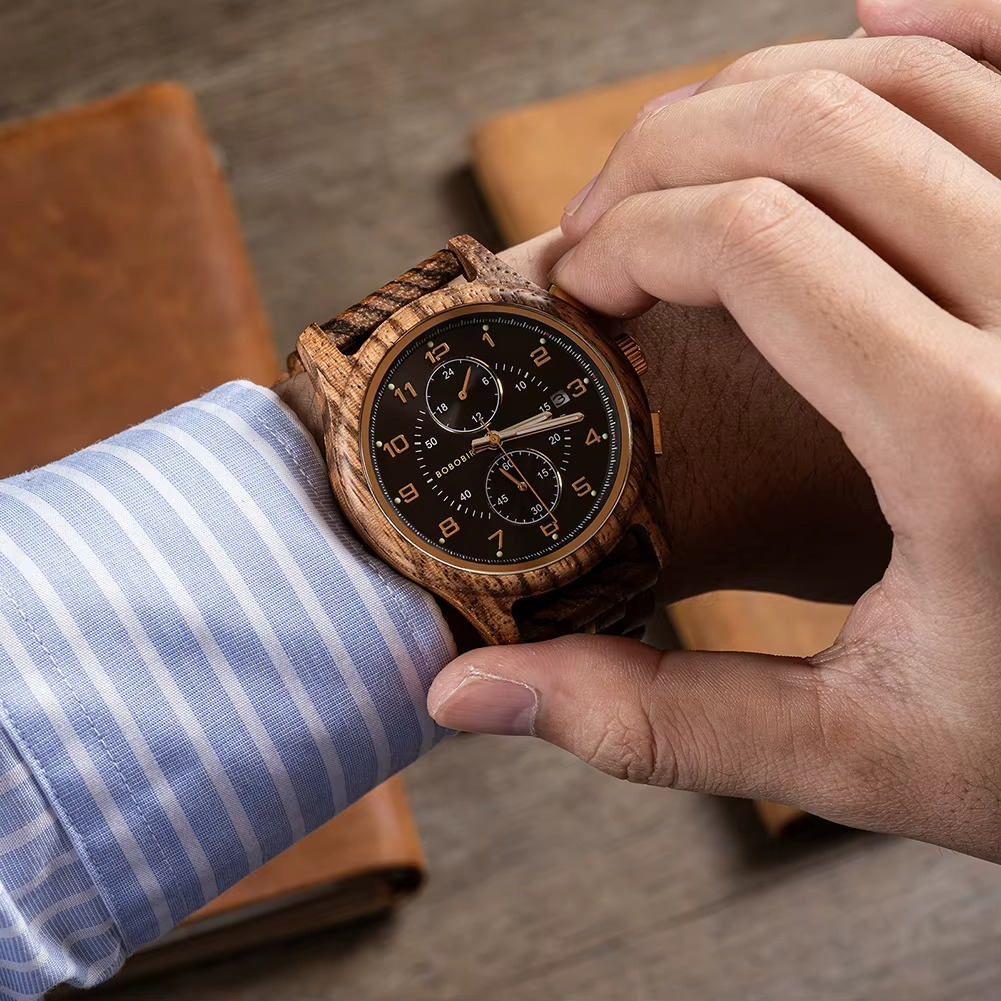 Montre en bois homme Walden en noyer avec cadran noir chronographe et aiguilles lumineuses portée au poignet