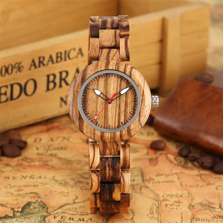 Montre en bois Lumina pour femme 36 mm avec aiguilles lumineuses et bracelet en bois naturel, vue de face sur fond vintage avec grains de café
