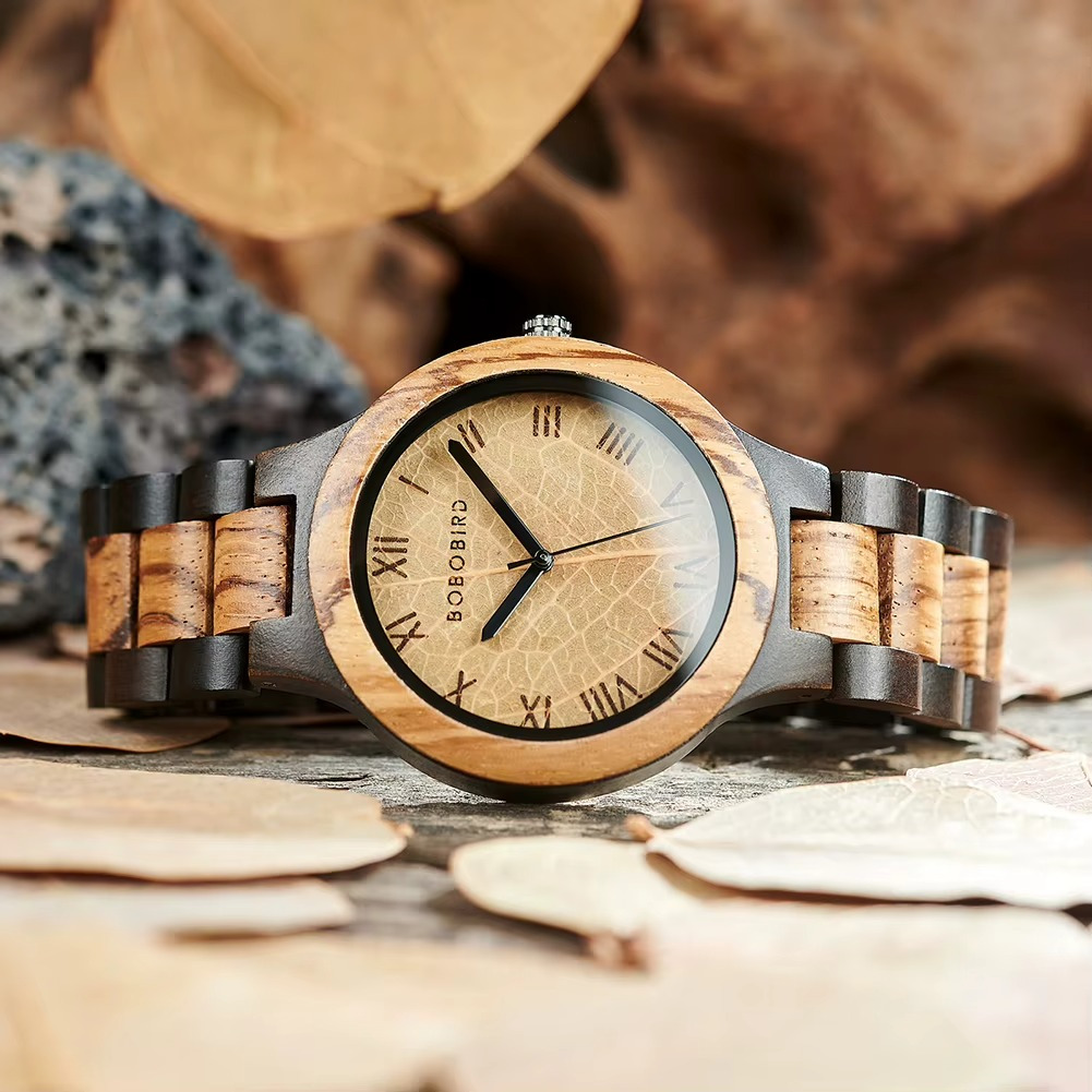 Montre en bois Sylva avec cadran en bois clair orné d'une feuille et chiffres romains, bracelet en bois foncé et clair