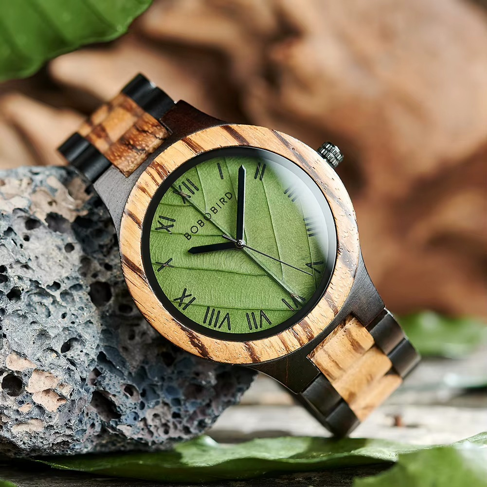 Montre en bois Sylva avec cadran vert motif feuille et chiffres romains, bracelet en bois clair et foncé