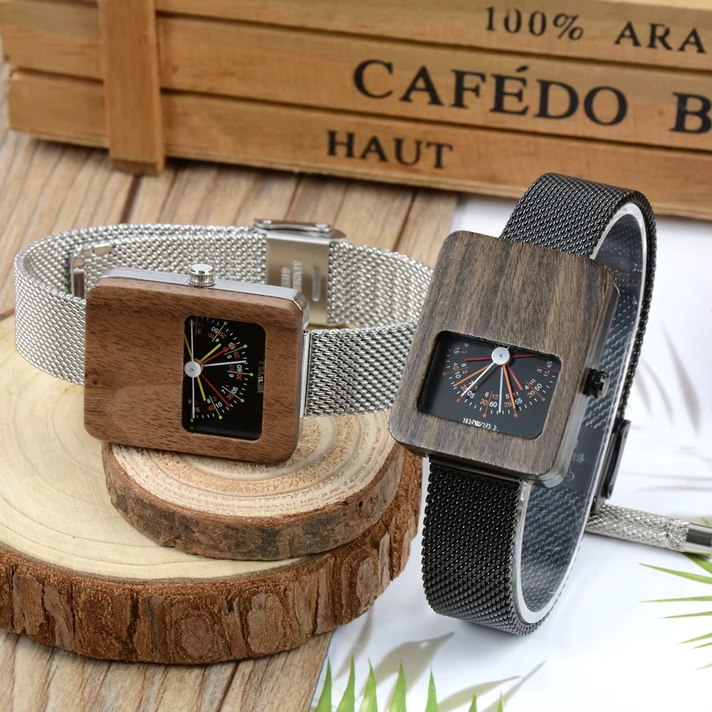 Montres Milan en bois et acier pour femme avec cadran éventail, bracelet maille argenté et noir posées sur rondins de bois